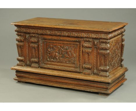 A large 19th century carved oak coffer, with moulded edge above a carved frieze with centre carved panel depicting a chariot,