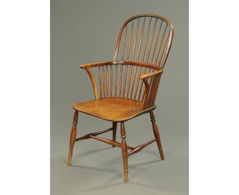 A 19th century stick back Windsor armchair, with long seat and raised on turned legs.  