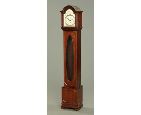 A mahogany grandmother clock, with arched hood, silvered brass dial and three-train movement above the glazed door, the base 