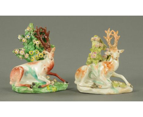 A pair of porcelain recumbent stags, each with bocage.  Height 11 cm.    CONDITION REPORT:  The left hand stag has the usual 