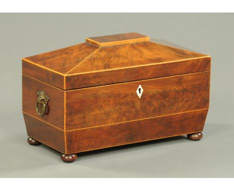 A Regency mahogany tea caddy, with centre aperture and two caddies, brass carrying handles and raised on bun feet.  Width 31 