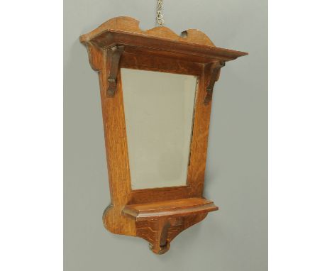 An oak framed Art & Crafts hall mirror and combined shelf.  Width 46 cm, height 63 cm. 