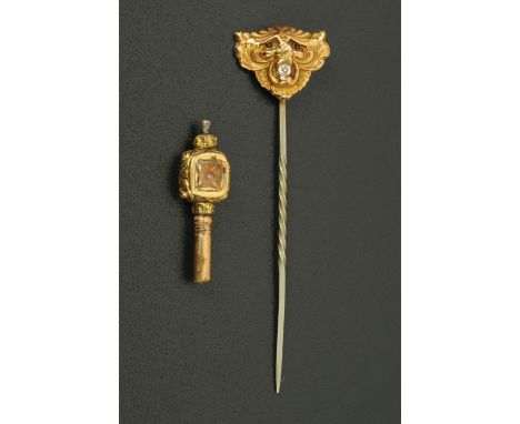 A gold coloured stick pin, lion mask form, set with a diamond, 1.4 grams gross, and a Victorian watch key.  