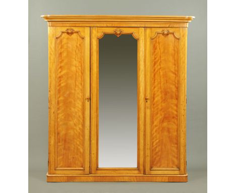 A Victorian satin walnut wardrobe, with detachable moulded cornice above a mirror door and two panelled doors enclosing hangi