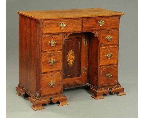 A George III mahogany kneehole desk, boxwood and ebony strung, with two frieze drawers, kneehole recess, cupboard and three f