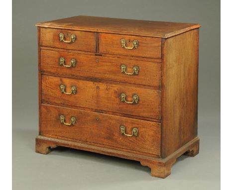 A George III mahogany chest of two short and three long graduated drawers, with brass drop handles with shaped backplates and