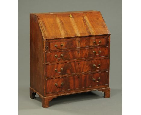 A Georgian walnut bureau, with four long graduated drawers with brass drop handles and raised on bracket feet.  Width 89.5 cm