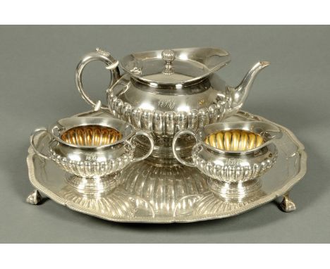 A three piece silver plated half lobed tea service, on circular tray with claw and ball feet. 