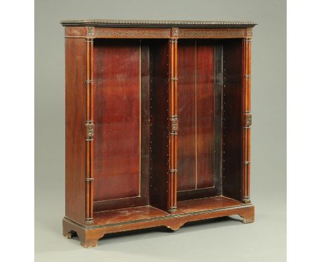 An Edwardian mahogany open bookcase, with moulded edge, blind fretwork frieze and cluster columns and raised on bracket feet.