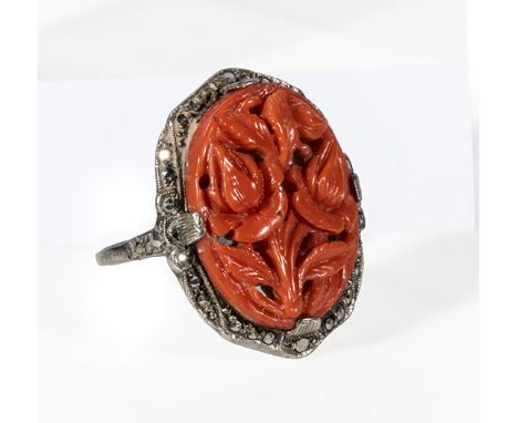 A white metal, marcasite and carved coral ring