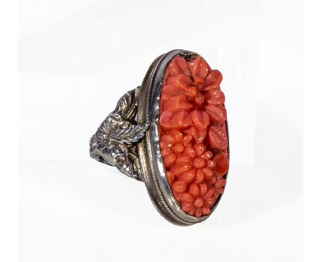 A white metal and carved coral ring
