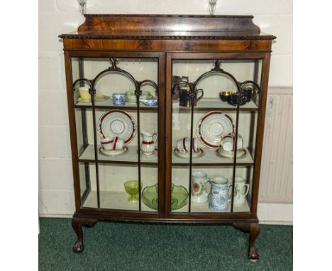 A 1930s mahogany display cabinet with ball and claw feet