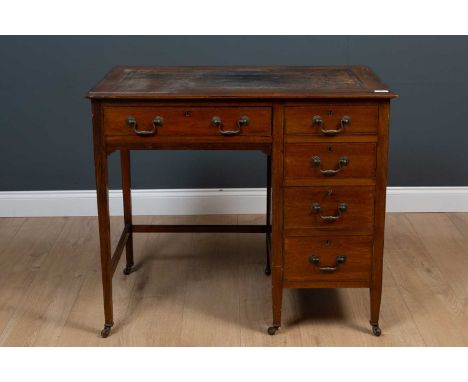 An Edwardian mahoganny writing desk with a leather inset top, 5 drawers with brass swan neck handles, all raised on square ta