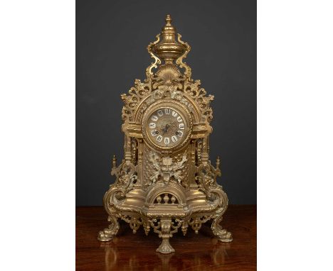 An Italian brass Imperial mantle clock the enamelled dial marked with roman numerals surrounded by brass scrolling floral and