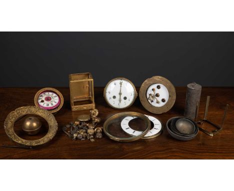 A collection of clock parts to include escapements, keys, pendulums, dials and further items together with a set of seven cer