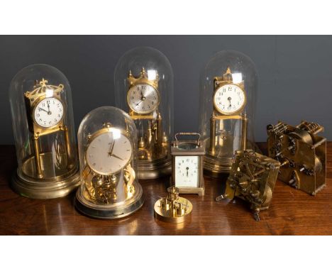 A group of seven various anniversary clocks, four under glass domes together with a brass carriage timepiece and clock parts/