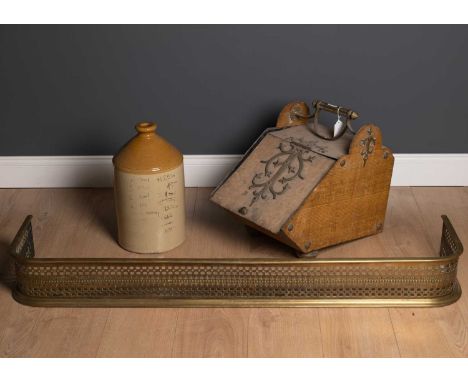 A brass pierced decorated fender 131cm wide x 30cm deep x 15cm high together with a brass mounted metal coal scuttle with woo