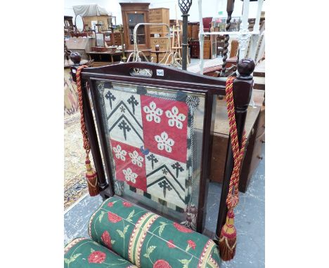A VINTAGE GLAZED FIRESCREEN HUNG WITH EMBROIDERED ARMORIAL BANNER. 