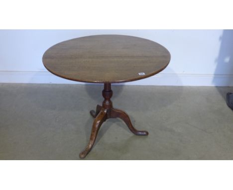 A Georgian oak tilting tripod supper table - the 82 cm diameter top raised on a turned stem 