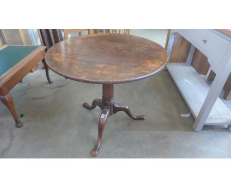 A Georgian mahogany tilting tripod supper table with a 75cm diameter top raised on a gun barrel stem - Height 68cm 