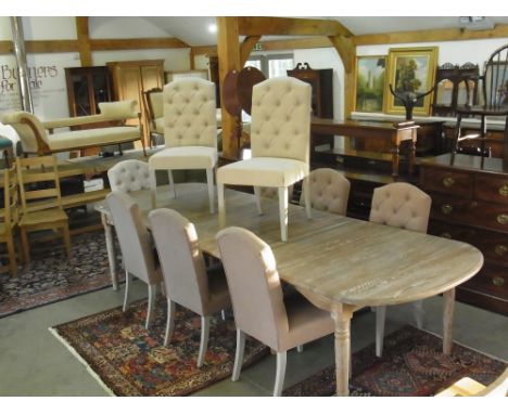 A Bramblecrest Provence extending dining table with four leaves, nine upholstered chairs - six dark cloth and three light clo
