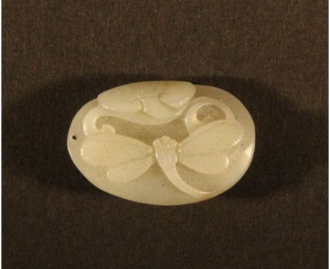 A small Chinese celadon jade pebble amulet decorated with a dragonfly and lotus leaf W 4cm