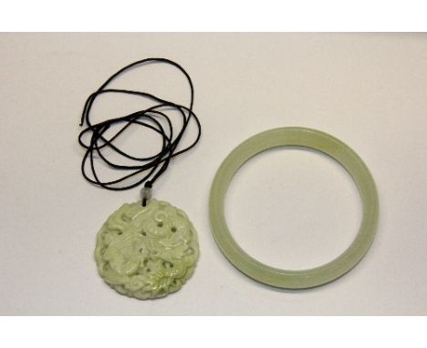 A Chinese green jade bangle and hardstone amulet