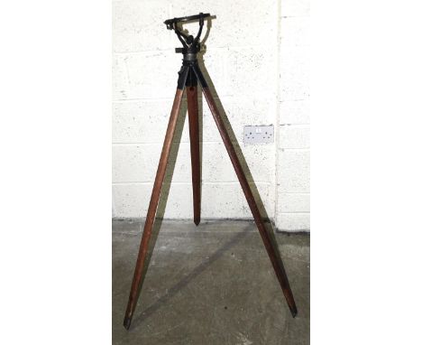 A military wood and brass tripod,&nbsp;marked with broad arrow and&nbsp;Helios Mark V, C&amp;D, B24445, 103cm and a wooden fo
