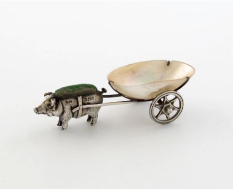 An Edwardian novelty silver pin cushion, by Adie and Lovekin, Birmingham 1909, modelled as a pig pulling a cart, the cart wit