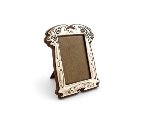 An Edwardian Art Nouveau silver photograph frame, by Charles Green and Co Limited, Birmingham 1906,  shaped upright rectangul