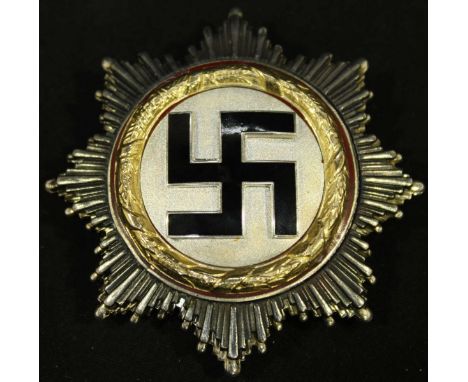 A WWII German Third Reich Deutsches Kreuz (German Cross) Gold order, with black enamel swastika on a silver ground, surrounde