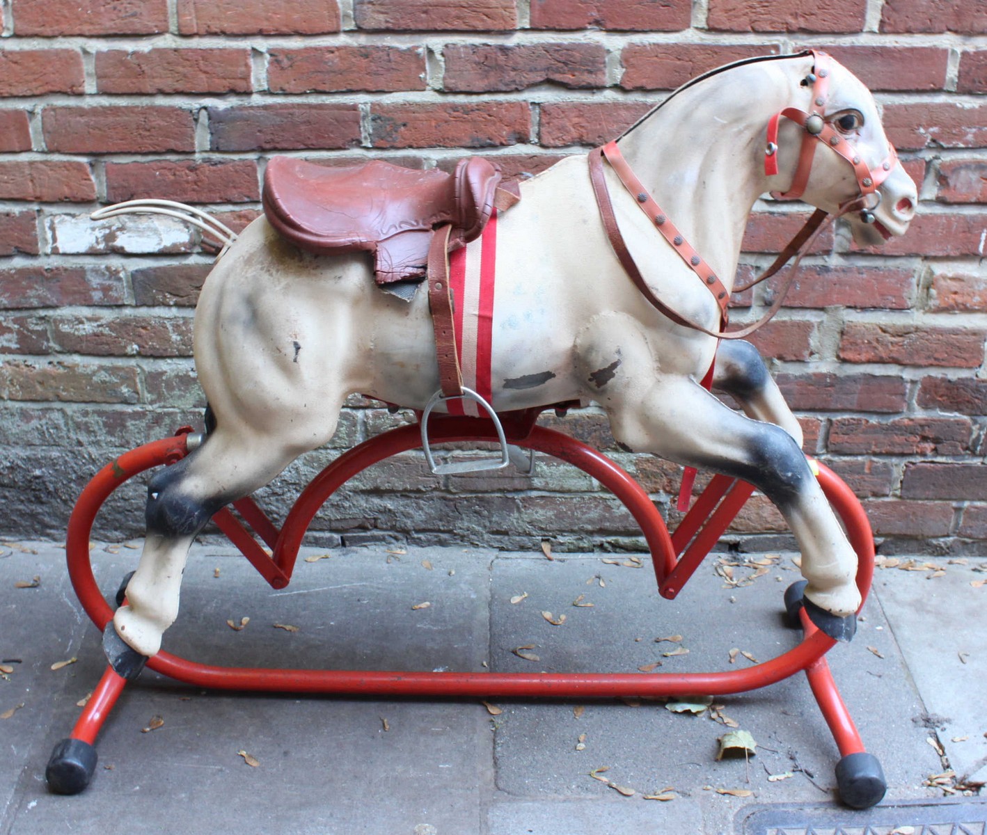 A mid 20th century Triang metal rocking horse, with realistically painted body, saddle and reins,