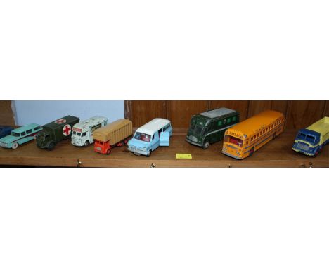 A shelf of assorted die cast toy trucks, vans and buses by Corgi, Dinky, Triang and others, all without boxes.