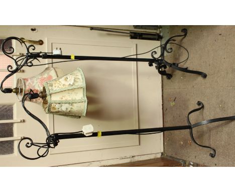 Two wrought iron standard lamps with scrolling decoration throughout, adjustable poles and light brackets, both raised on thr