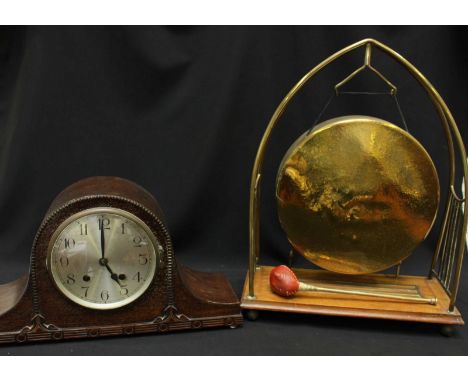 An Edwardian mahogany and brass dinner gong, and a 1930s oak mantle clock. (2)