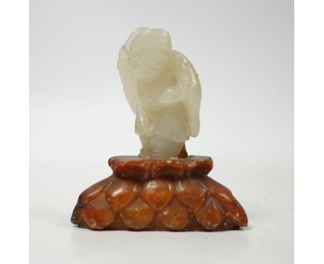A Chinese pale celadon jade figure of a man holding a fly whisk, Qing dynasty, 5.2cm high, soapstone stand, total height 8cm 