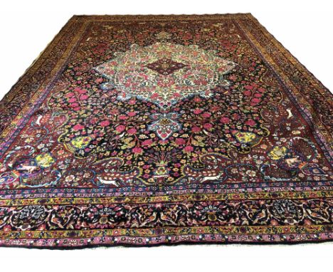 KERMAN LAVER DESIGN CARPET, 497cm x 362cm, central hunting and floral design medallion on a matching field, surrounded by cor