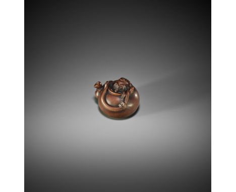 HO RAKUMIN: A FINE WOOD NETSUKE OF AN OCTOPUS INSIDE A TETSUBINBy Ho Rakumin, signed RakuminJapan, Edo, 19th century, Edo per