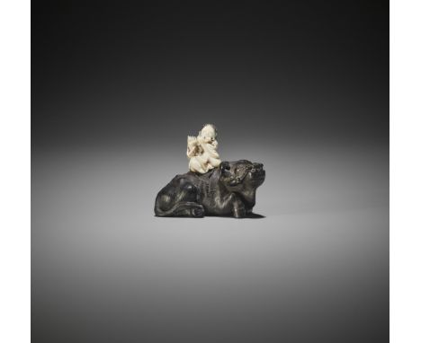 AN IVORY AND EBONY WOOD NETSUKE OF A HERDBOY WITH OXJapan, Edo/Tokyo, second half of 19th centuryCarved as an ivory herdboy p