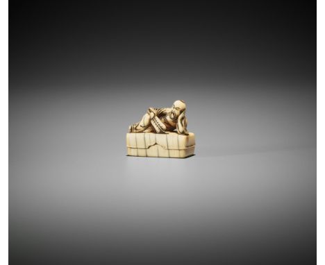 AN IVORY NETSUKE OF AN IMMORTAL ON BOXJapan, late 17th to early 18th century, Edo period (1615-1868)Finely carved as a reclin