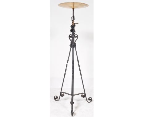 A contemporary industrial ebonised metal standard lamp having scrolled embellishments to the single column raised on tripod s