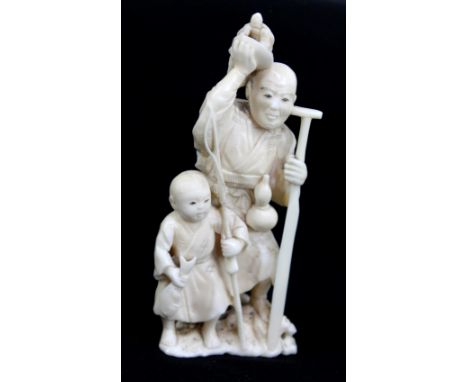 A Japanese Meiji period carved ivory okimono of a gentleman holding a tortoise and paddle with gourd/flask to his left side a