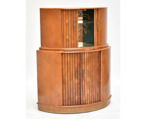 An Art Deco walnut cocktail cabinet with mirrored interior above twin tambour doors enclosing single shelf and bottle rack, 1