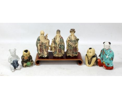 Three 20th century Chinese resin figures of immortals, two figures of boys and two porcelain examples, also a hardwood stand 