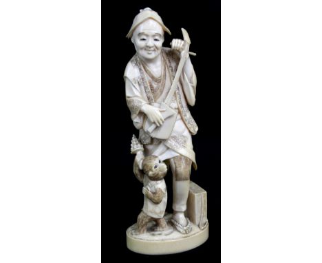 TOKYO SCHOOL; a good Japanese Meiji period carved ivory okimono depicting a gentleman playing a musical instrument with monke