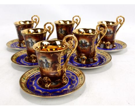 A set of six 20th century porcelain coffee cans and saucers with gilt glazed handles and interiors, each piece transfer decor