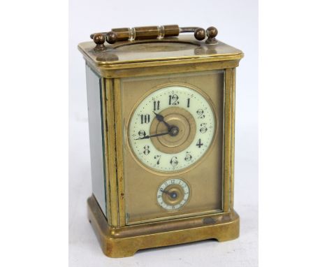 A late 19th/early 20th century brass cased carriage clock, the circular porcelain dial set with Arabic numerals and with subs