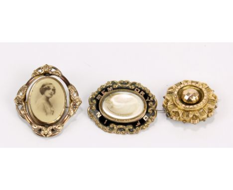 Three Victorian gilt metal mourning brooches, one with black enamel and hair in glazed aperture, the other two with glazed lo