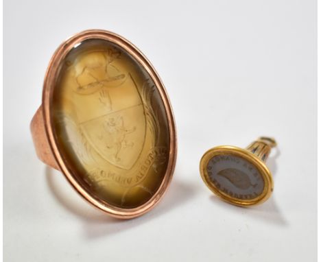 A large Victorian yellow metal intaglio ring, the oval platform carved with a pig above a shield with hand and rampant lion w