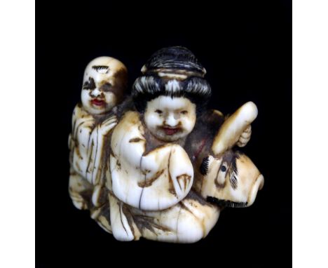 A 19th century Japanese carved ivory netsuke of Okame seated holding a konoha tengu mask, height 3cm, length 3.2cm.Additional